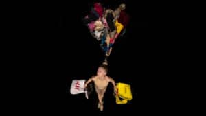 Delia Ceruti hangs from her hair, her hands are full of shopping bags and her hair is attached to a mountain of clothes