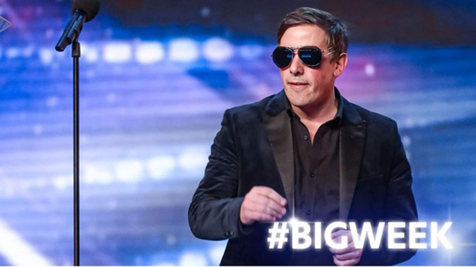 Christian Lee performing in Britain's Got Talent, wearing sunglasses and standing next to a mircropone
