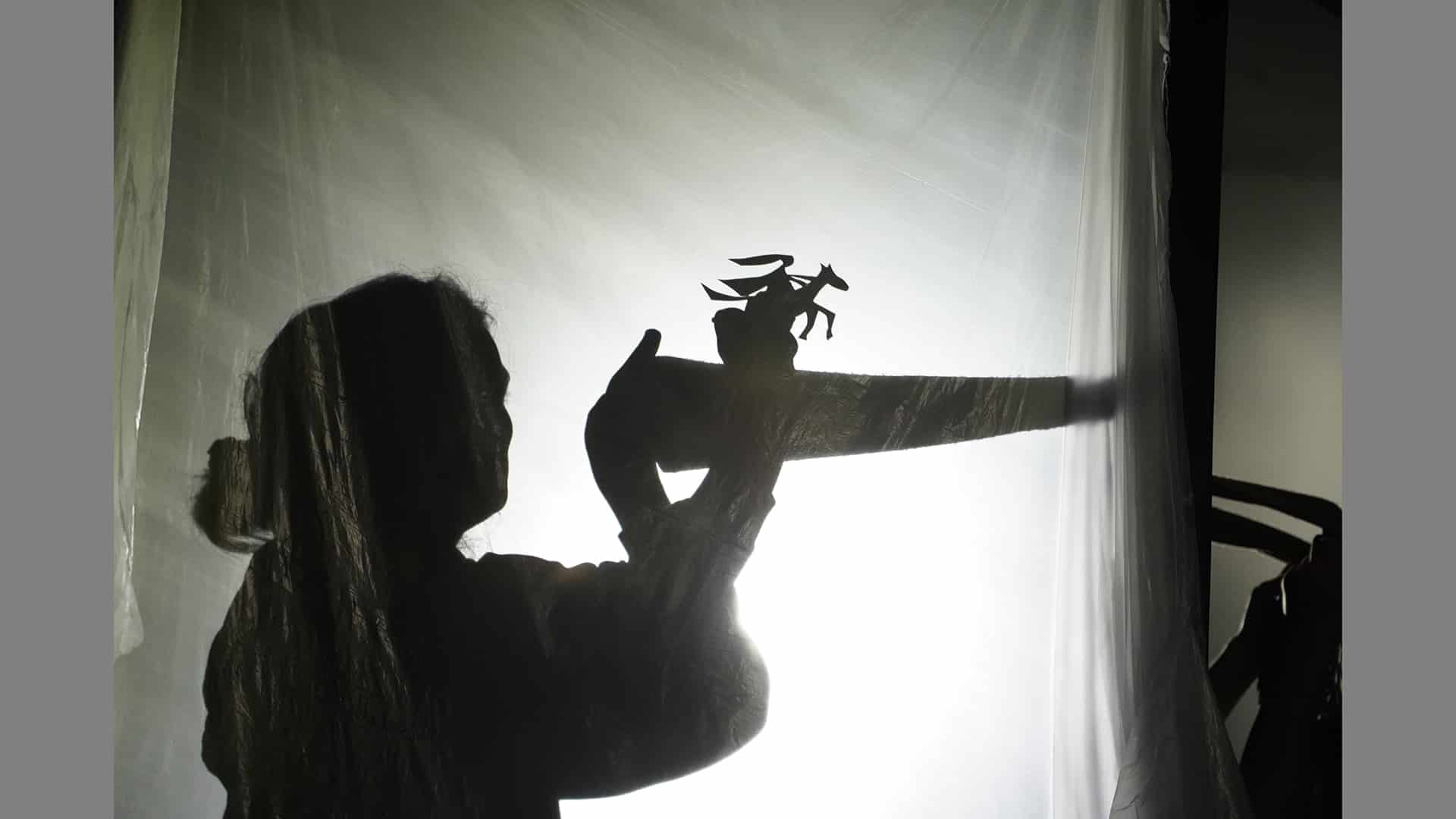 Shadowpuppet scene featuring a figure riding a galloping horse