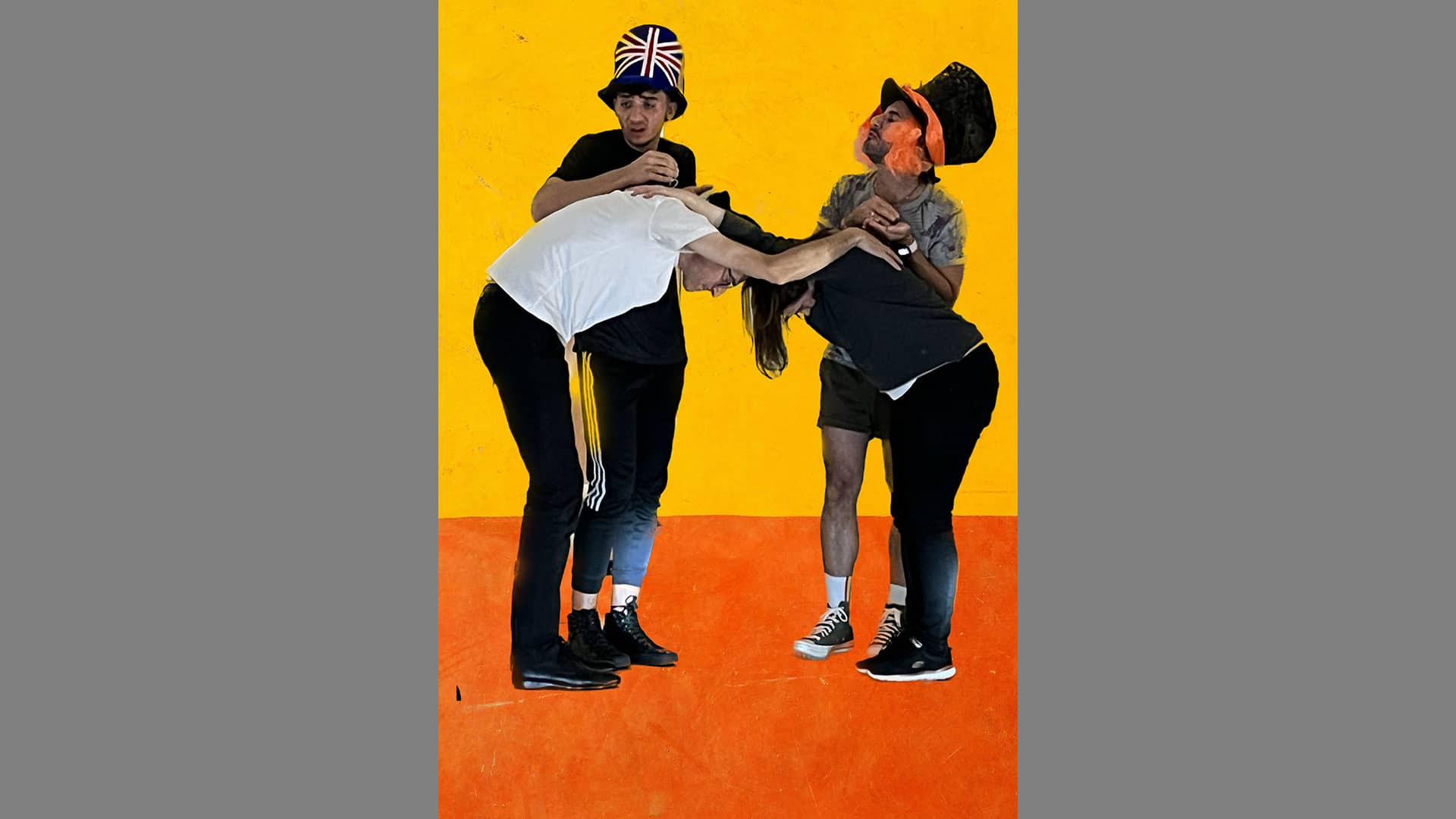 Four figures are positioned in front of a yellow and orange background. Two bend towards each other, laying their hands on each other's backs. Behind them the other two look to one side. They wear massive top hats