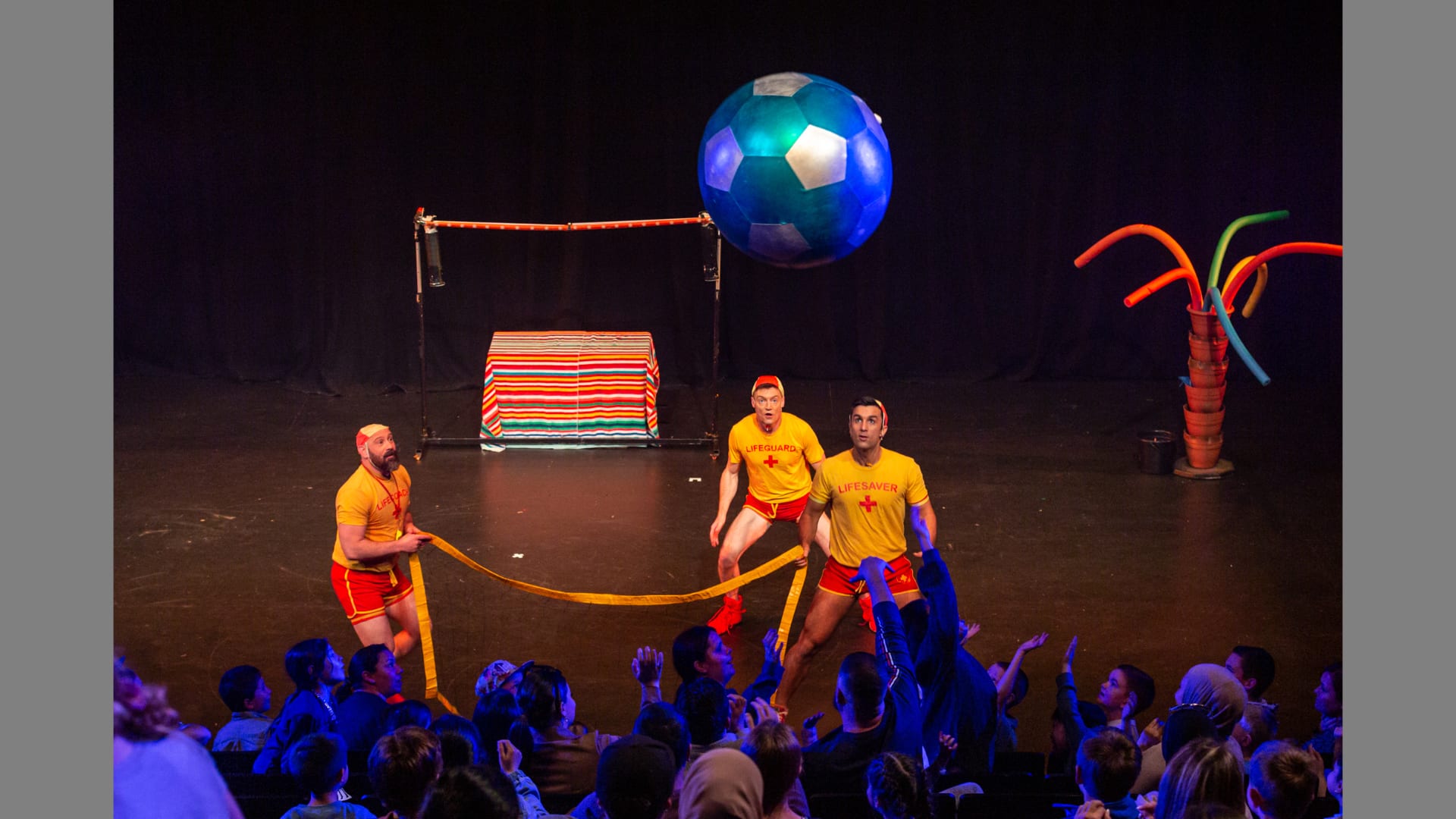 The Dummies keep watch of a bouncy ball which is being bounced around the audience