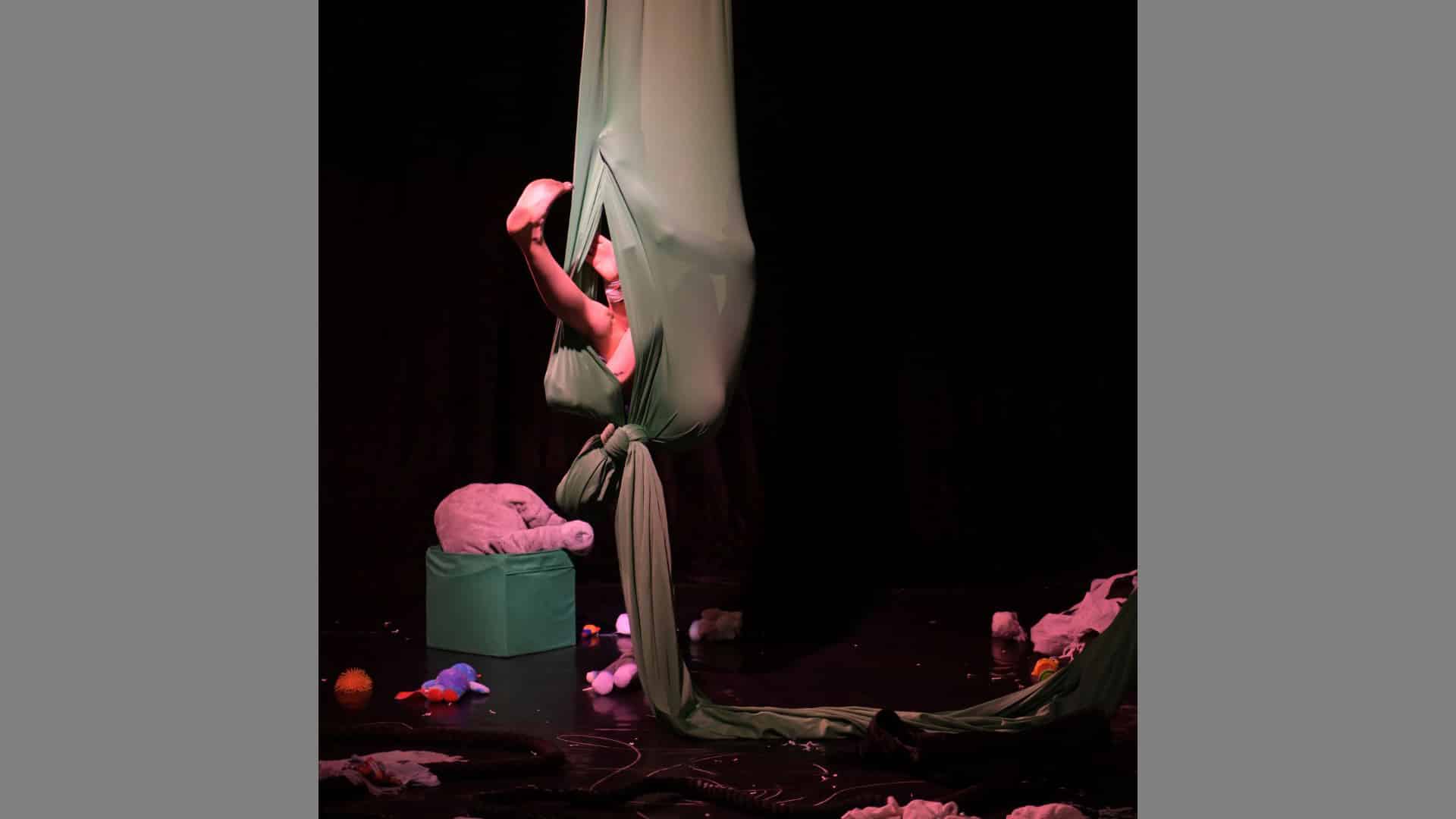 The performer is hidden in a cocoon of fabric. Only one leg is visible as it sticks out