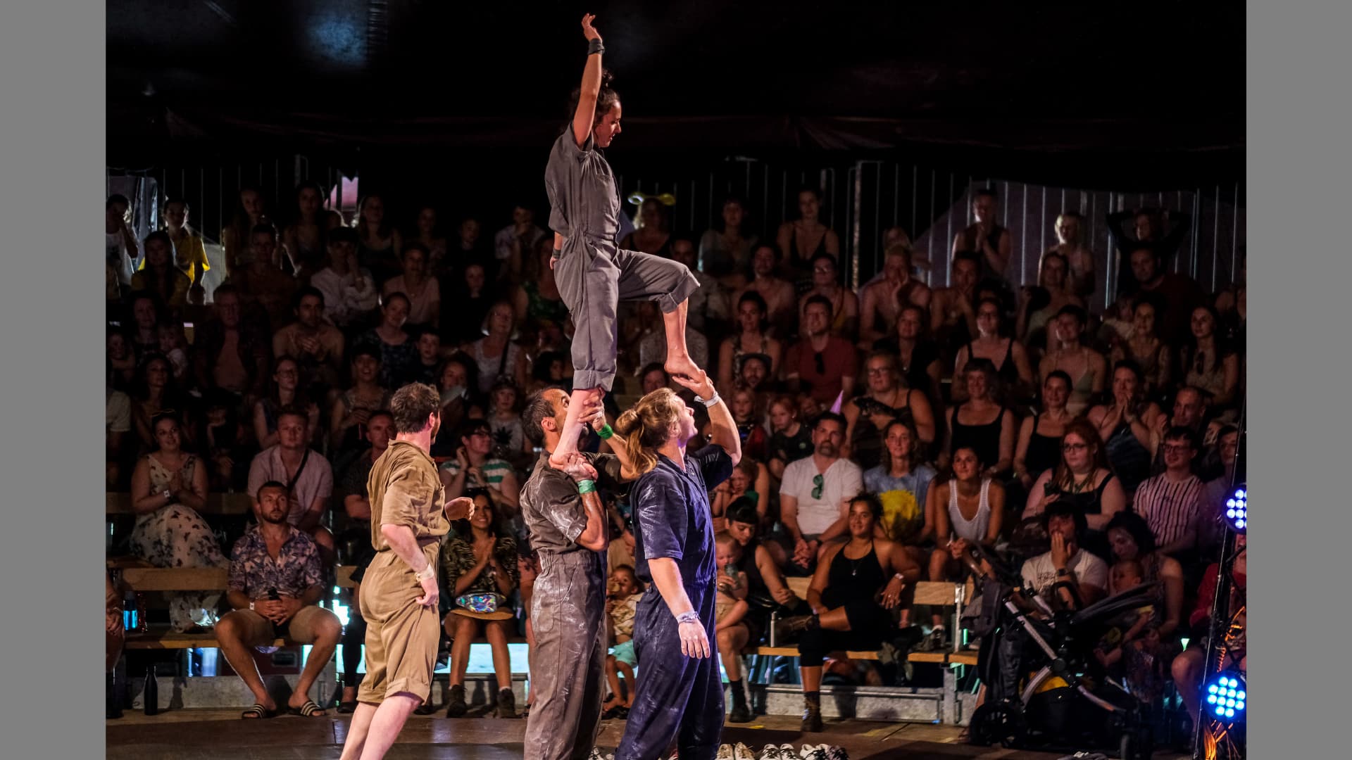 A performer climbs up the bodies of his fellow cast members as if he were walking up a flight of stairs