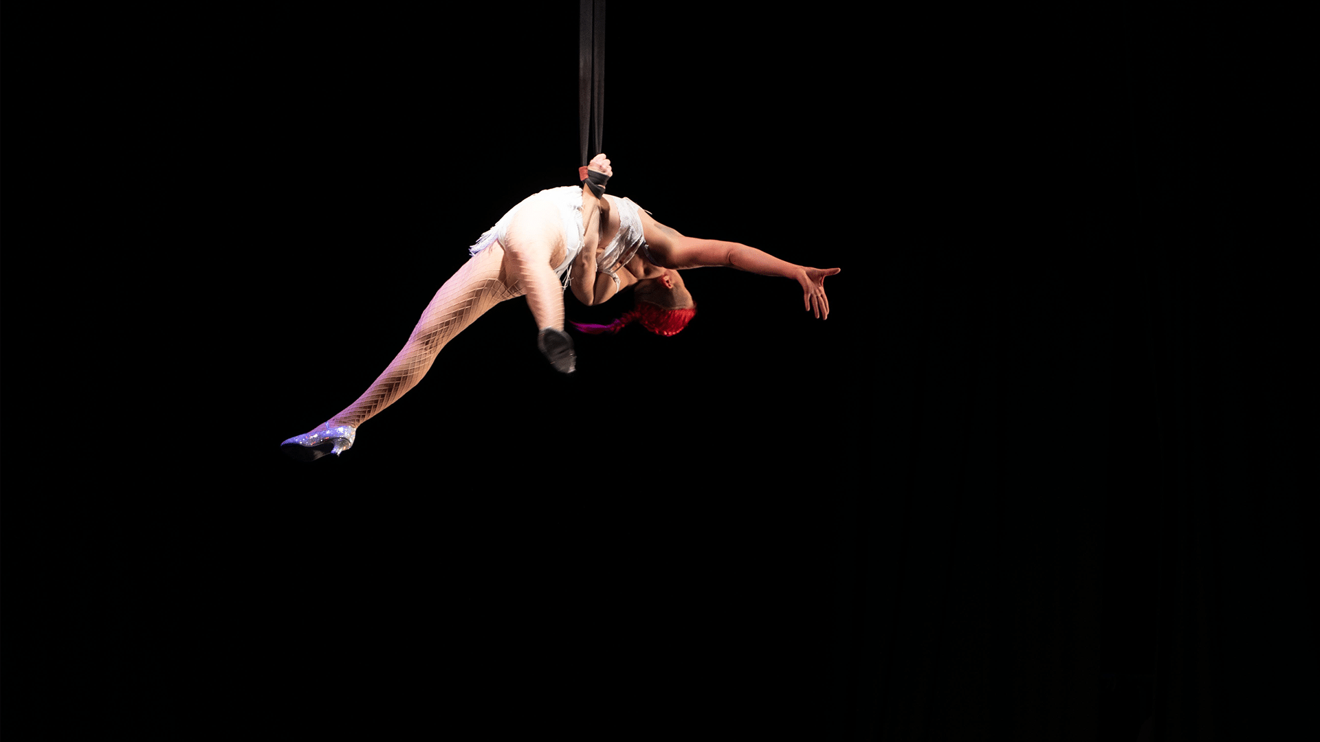 A straps artist performs as side planche.